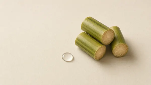 Cut pieces of green sugarcane beside a clear droplet