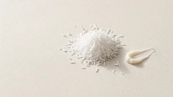 A mound of white crystalline powder beside a thin cream swatch