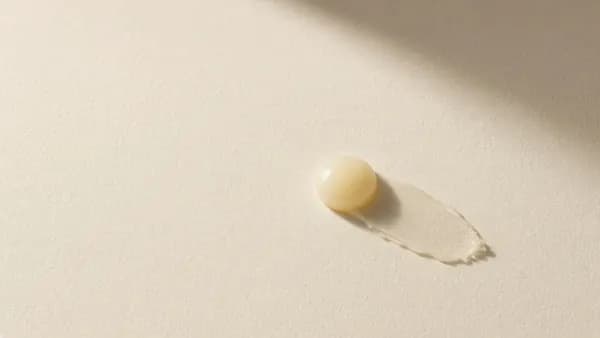 A small dab of pale yellow cream on cream paper
