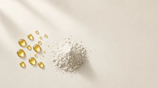 Golden oil droplets scattered beside a mound of white powder