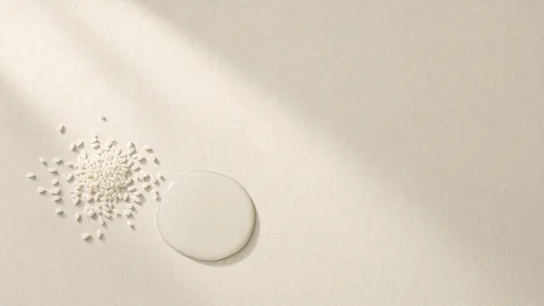 Scattered white rice grains beside a pool of cloudy rice water